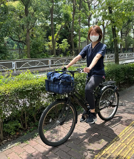 電動自転車で訪問に向かうスタッフ