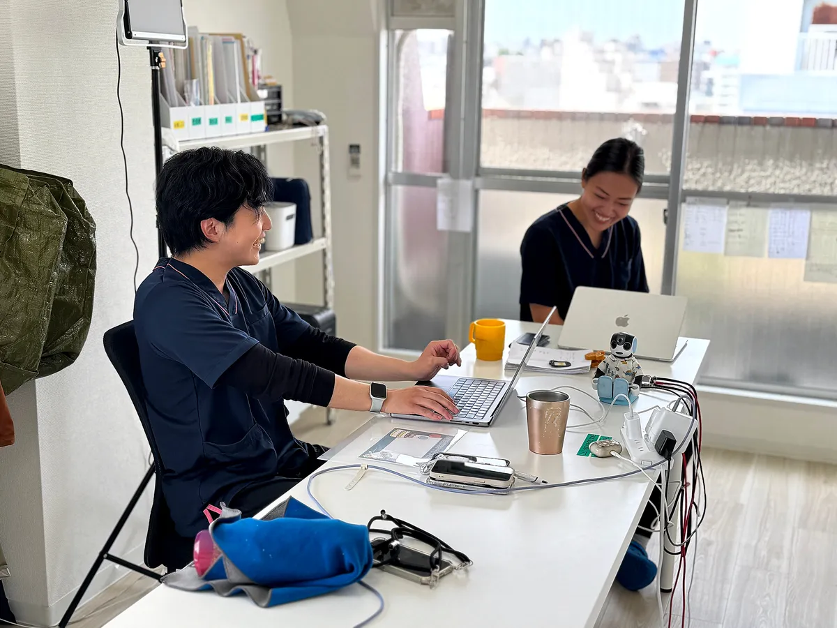 事務所のデスクで記録を進めるスタッフ